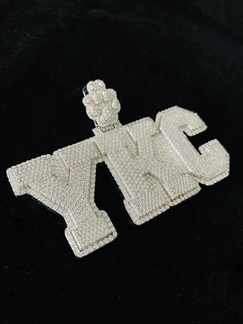 Diamond encrusted YKC letter pendant chain necklace on a black background