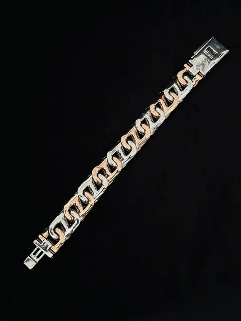 A two-tone chain link bracelet with alternating polished silver and rose gold plated links