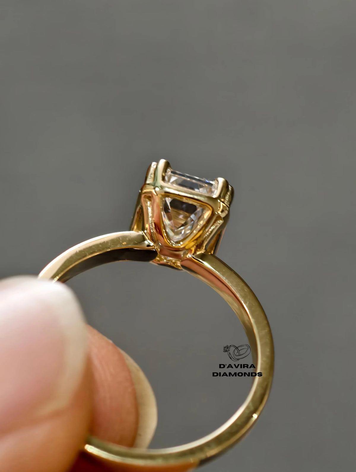 Side profile view of a ring with a emerald cut diamond in a classic basket prong setting