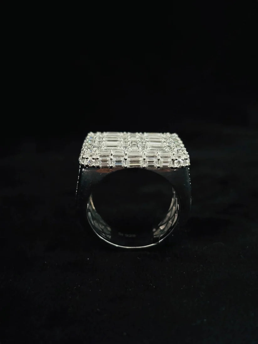 Silver men's signet style ring with a flat square top surface covered in rows of clear baguette cut diamonds