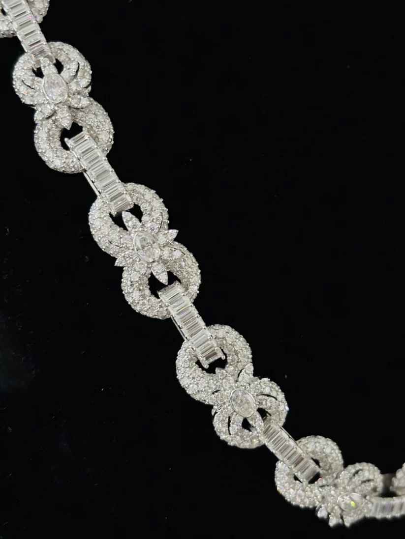 Close-up of an intricate diamond statement bracelet with alternating baguette bar links and pave diamond loops