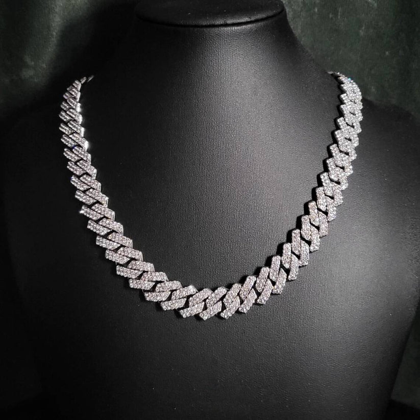 Silver iced out prong-set Cuban link chain necklace displayed on a black mannequin bust