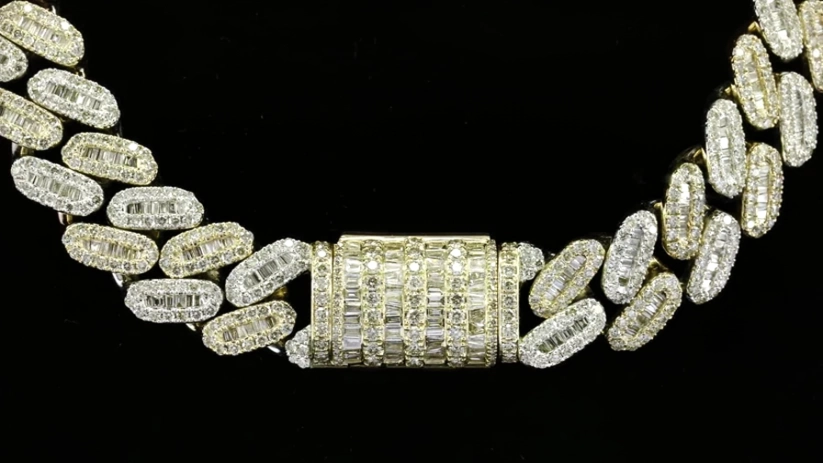 close up of A yellow gold plated chain necklace heavily embellished with clear diamonds