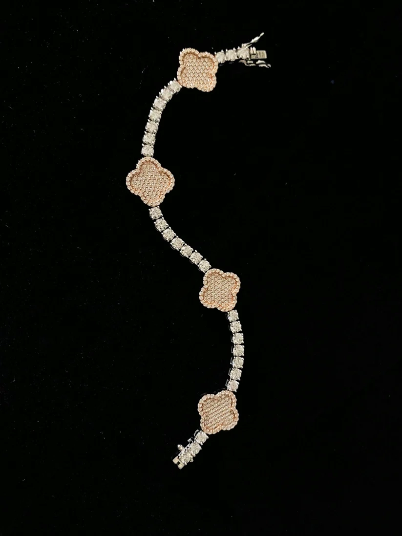 Two-tone diamond clover link bracelet on a black background
