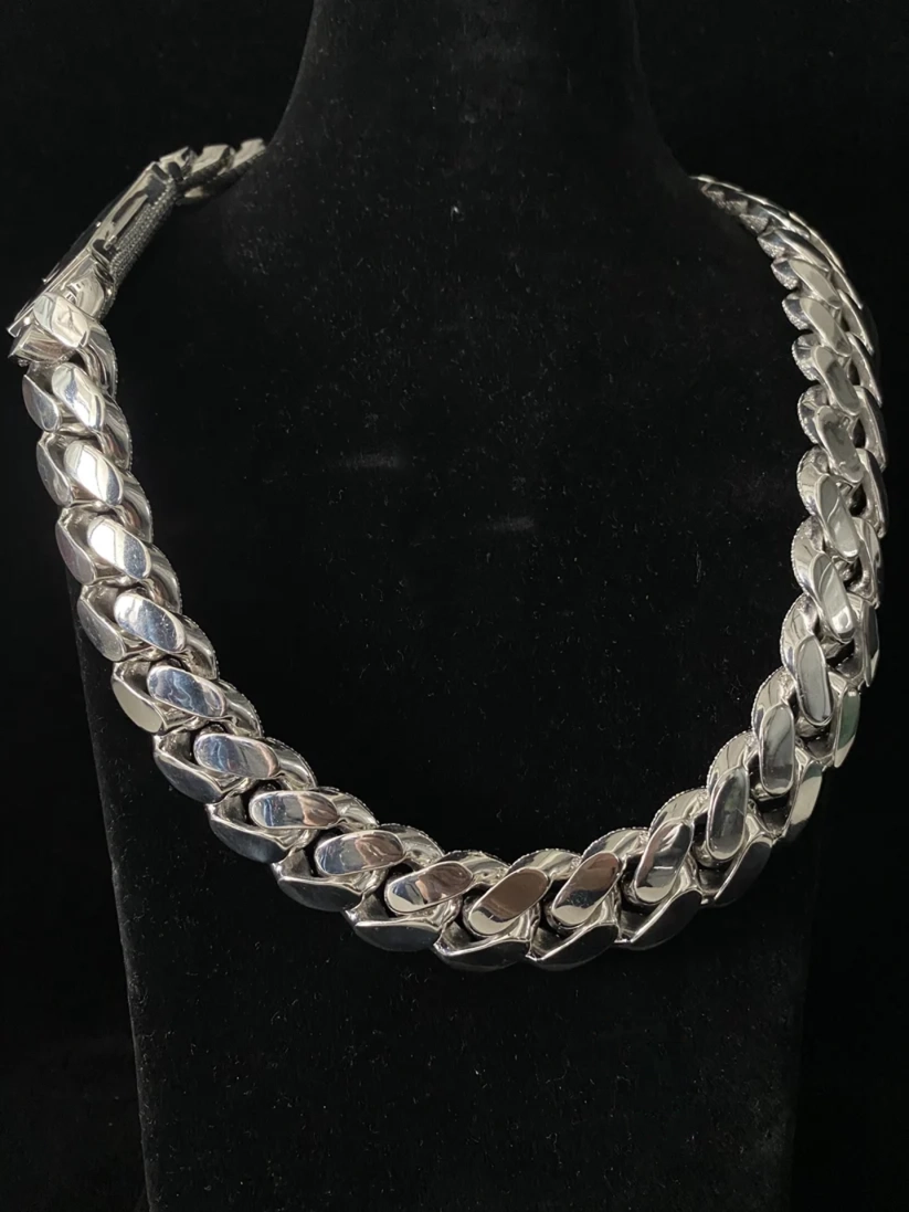 A back view chunky silver Cuban link chain necklace displayed on a black velvet jewelry bust