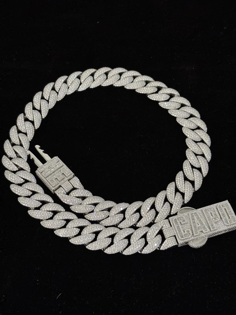 Iced-out silver Cuban link chain necklace with a custom diamond Capo nameplate clasp