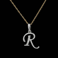 front view Diamond initial R pendant necklace in white gold on a gold rope chain