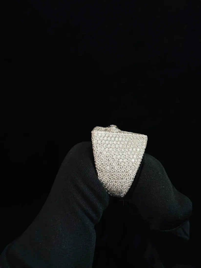 A side view small, rectangular silver clutch or envelope-style handbag held by a black-gloved hand