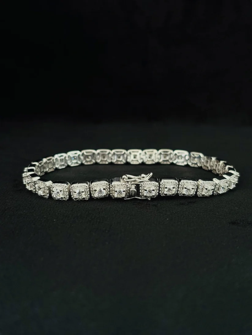 Sterling silver square halo tennis bracelet with moissanite stones on a black display