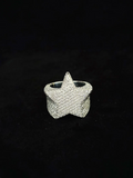 A silver ring shaped like a five-pointed star, heavily embellished with diamond