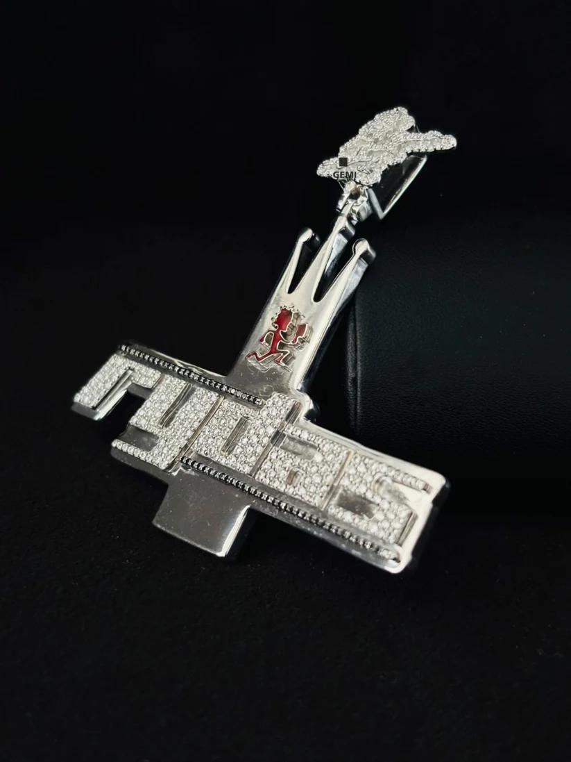Iced out silver Rydas hip hop pendant necklace charm paved with moissanite diamonds against a dark background.
