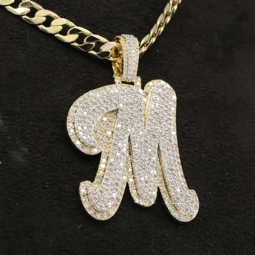 Diamond custom initial M pendant necklace with gold Cuban link chain.