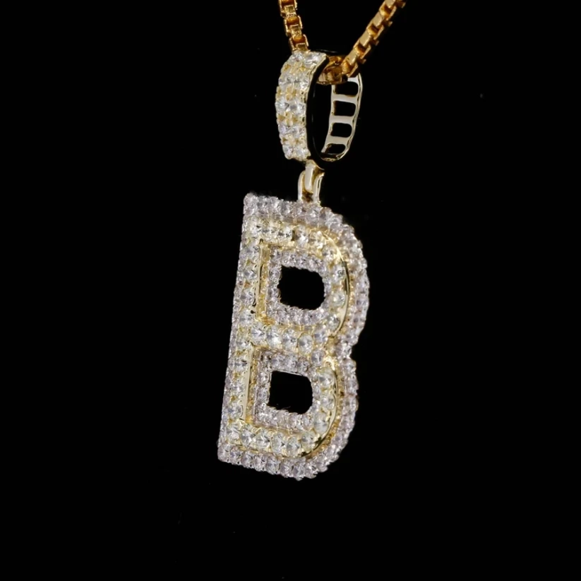 Gold bubble letter B pendant necklace encrusted with pave diamonds against a black background