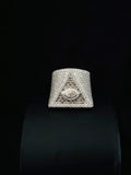 A large statement ring featuring a pyramid design paved with diamond and a central eye motif