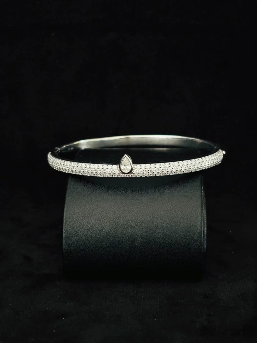 A Close-up view Silver pave diamond cuff bracelet with a central teardrop diamond accent