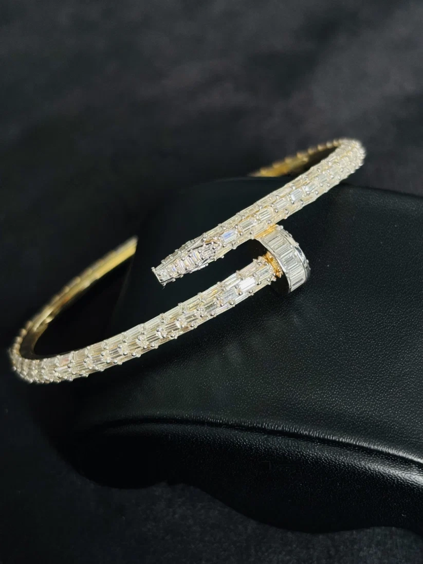 A close-up view Gold-toned diamond nail bracelet with baguette-set stones
