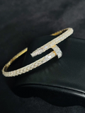 A close-up view Gold-toned diamond nail bracelet with baguette-set stones