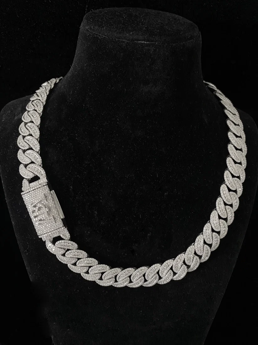 Close-up of a thick silver Cuban link chain necklace covered in pave diamonds
