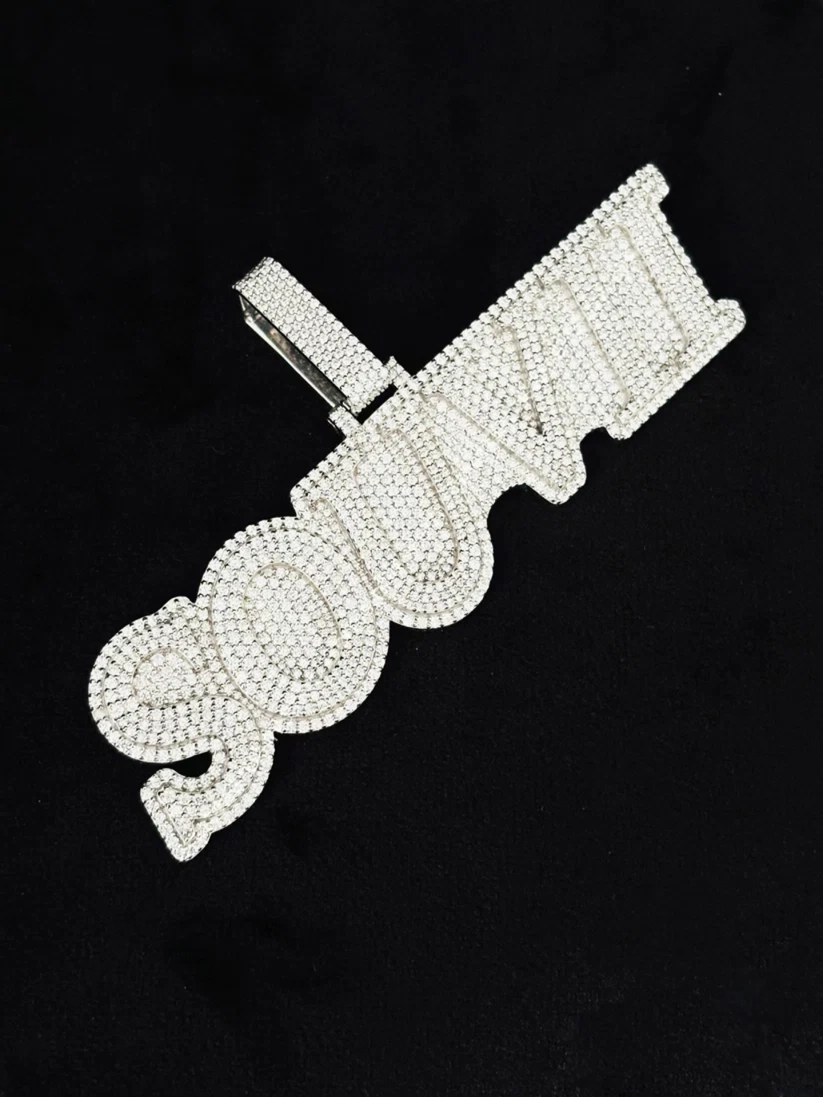Custom iced-out moissanite letter pendant in silver bubble script style.