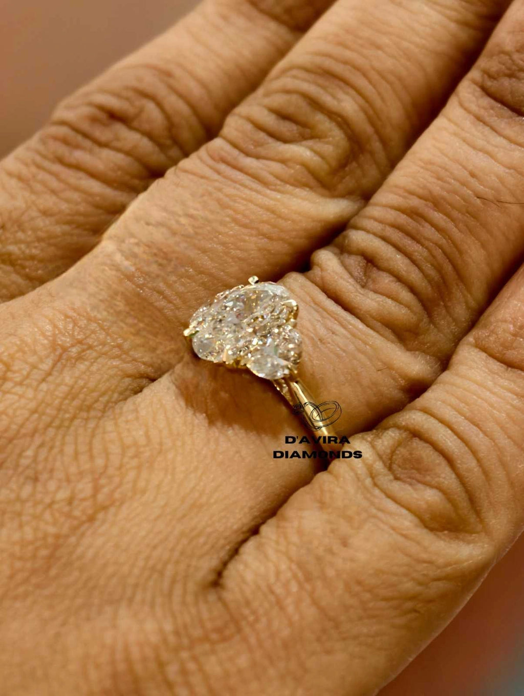 side view of a three stone oval lab grown diamond ring in yellow gold