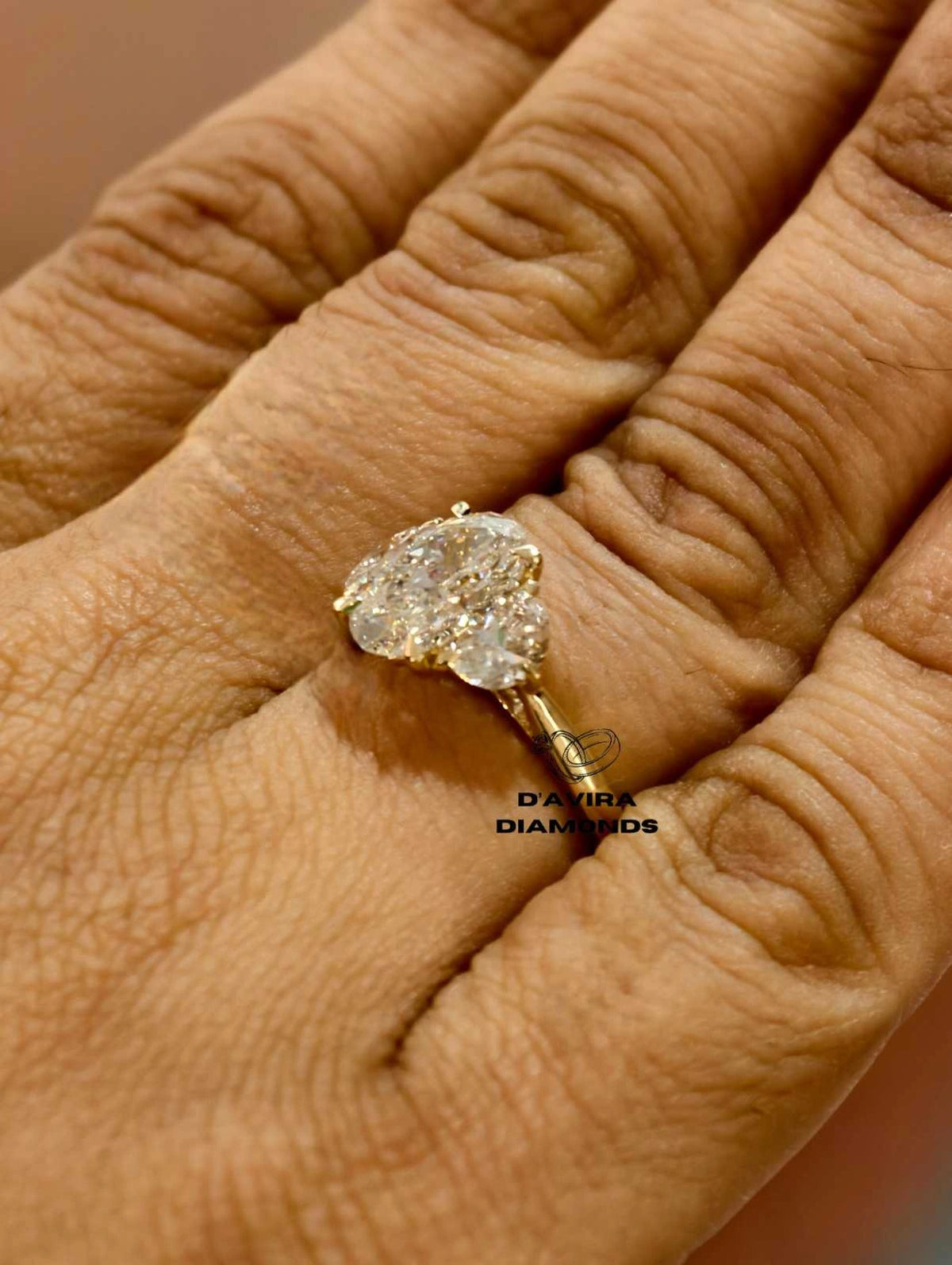 side view of a three stone oval lab grown diamond ring in yellow gold