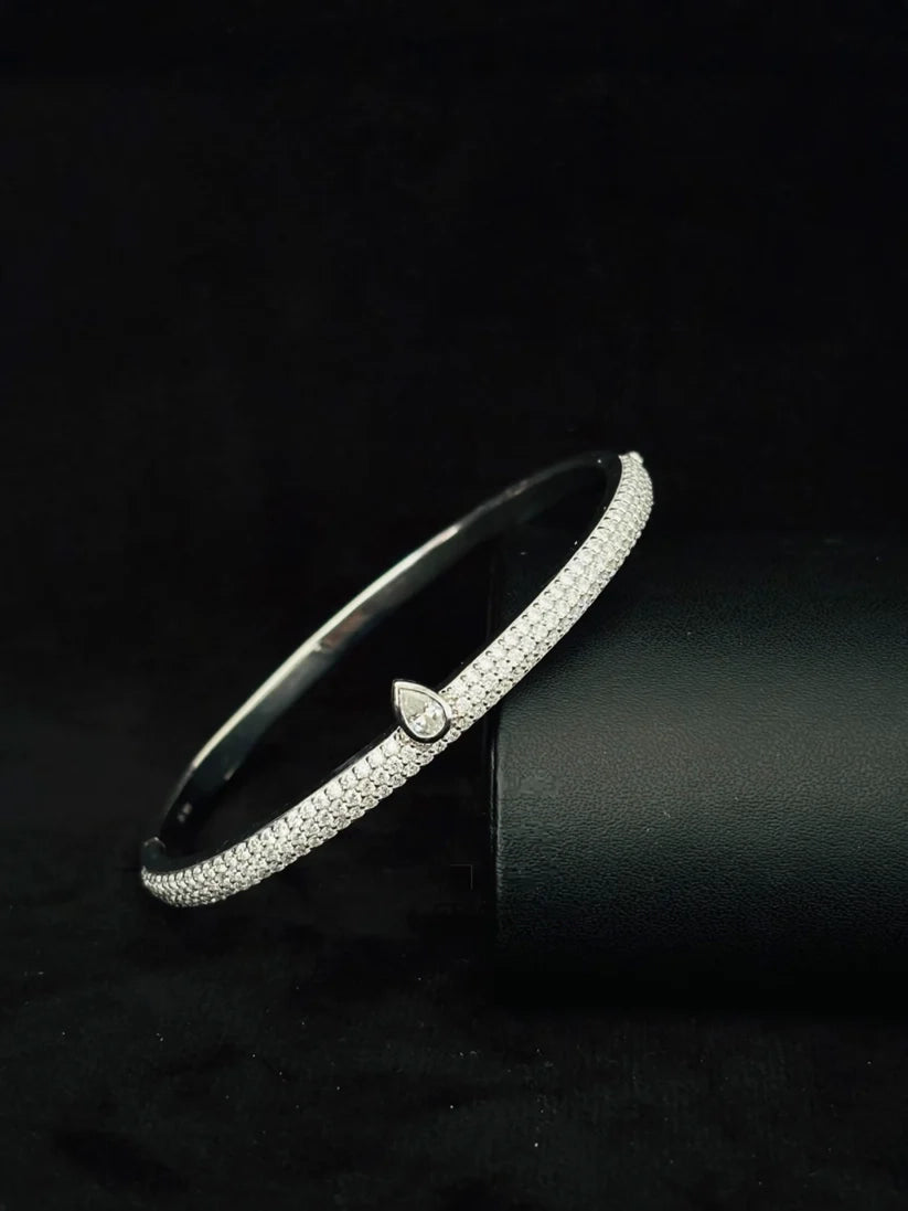 Silver pave diamond bangle bracelet with teardrop accent on stand
