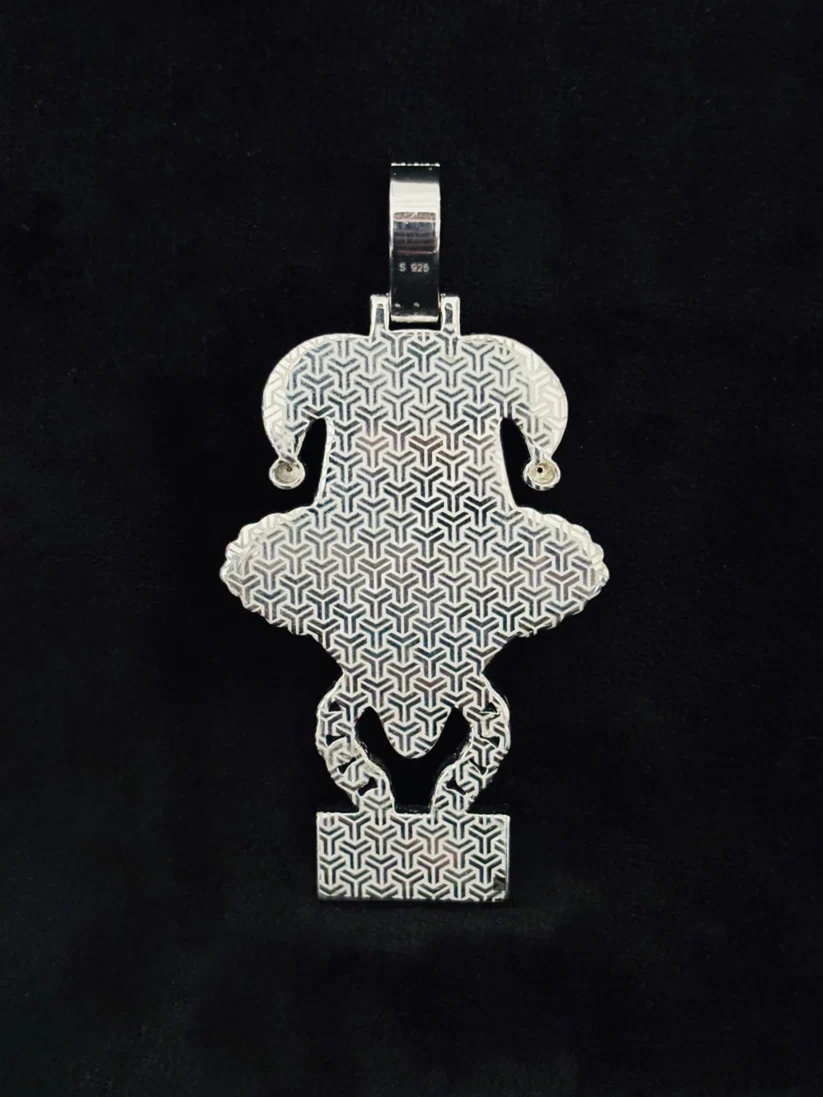 A silver pendant featuring a geometric interlocking pattern, shaped like a stylized vase or medallion 