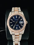 front view Fully iced-out two-tone rose gold and diamond-paved custom Rolex Datejust luxury watch with a navy blue dial.
