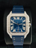 Luxury iced-out Cartier Santos watch featuring a blue dial, custom diamond bezel, and matching blue rubber band