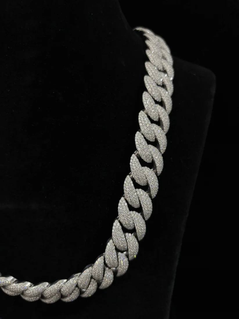 Silver diamond-encrusted Miami Cuban link chain necklace on a black display stand