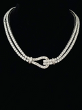 Double strand diamond tennis necklace with a paved horseshoe buckle clasp set in white gold.
