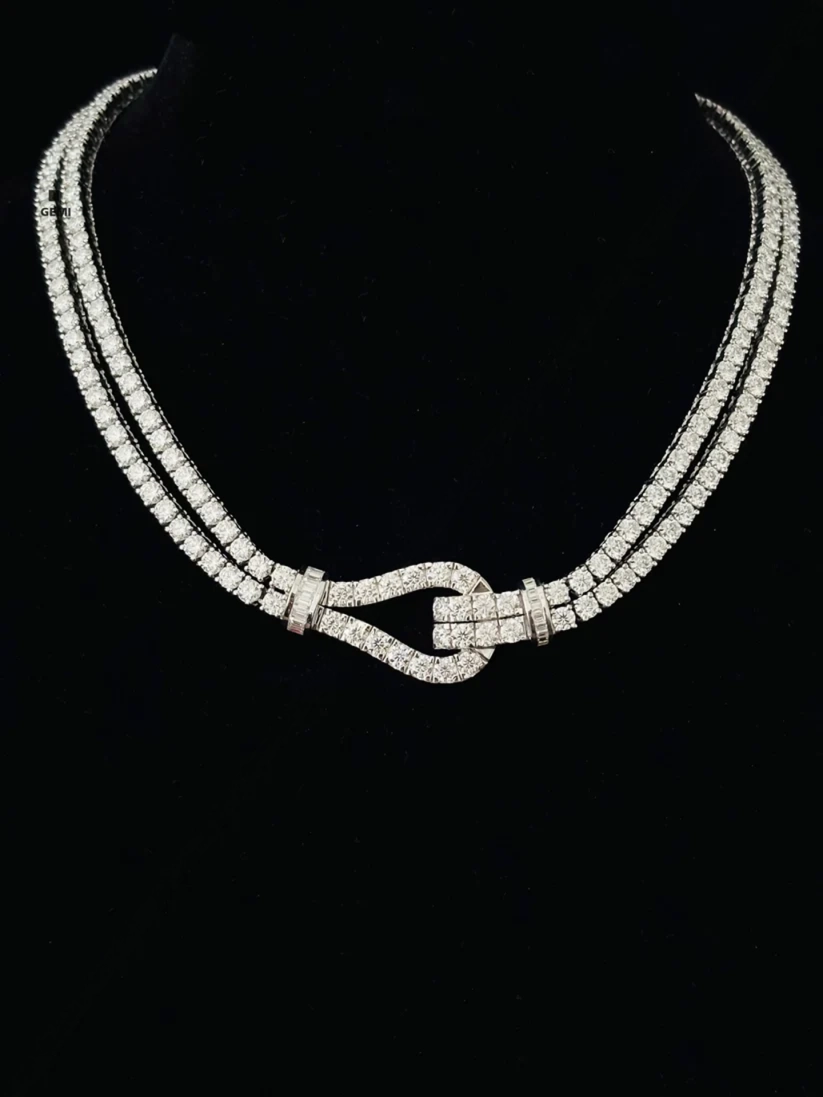 Double strand diamond tennis necklace with a paved horseshoe buckle clasp set in white gold.