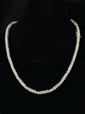 Women's sparkling diamond tennis chain necklace jewelry close-up.