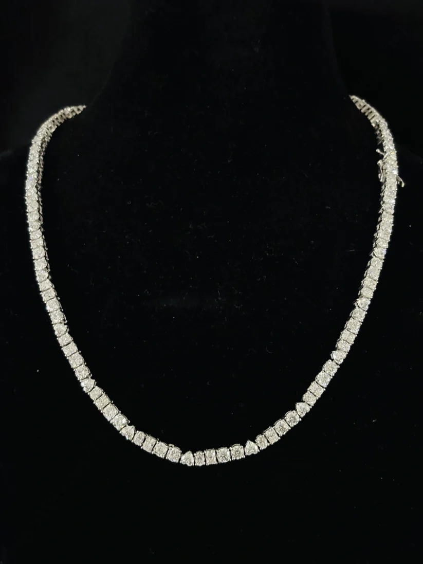 Women's sparkling diamond tennis chain necklace jewelry close-up.