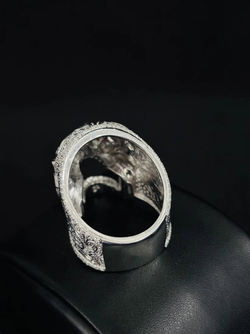 Ornate silver skull ring with intricate filigree engravings and cutout side design