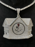 front view Diamond house pendant with a bleeding smile logo on a tennis chain.