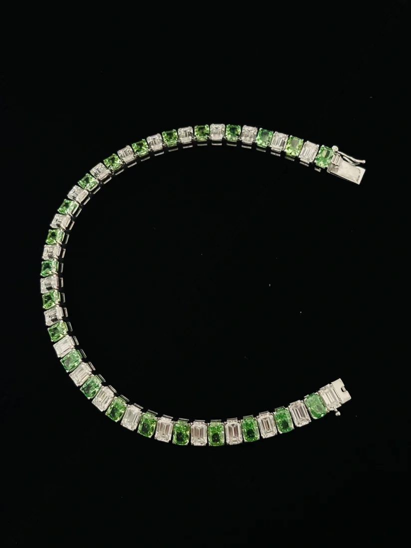A front view curved tennis bracelet featuring alternating gemstones in a silver setting