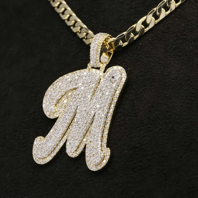 Gold necklace with a 'M' pendant on a black background