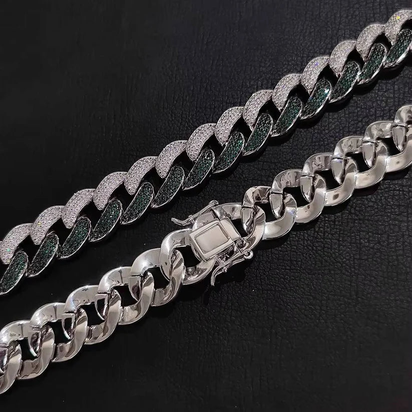Silver Cuban link chains with pave diamond and green gemstone detailing