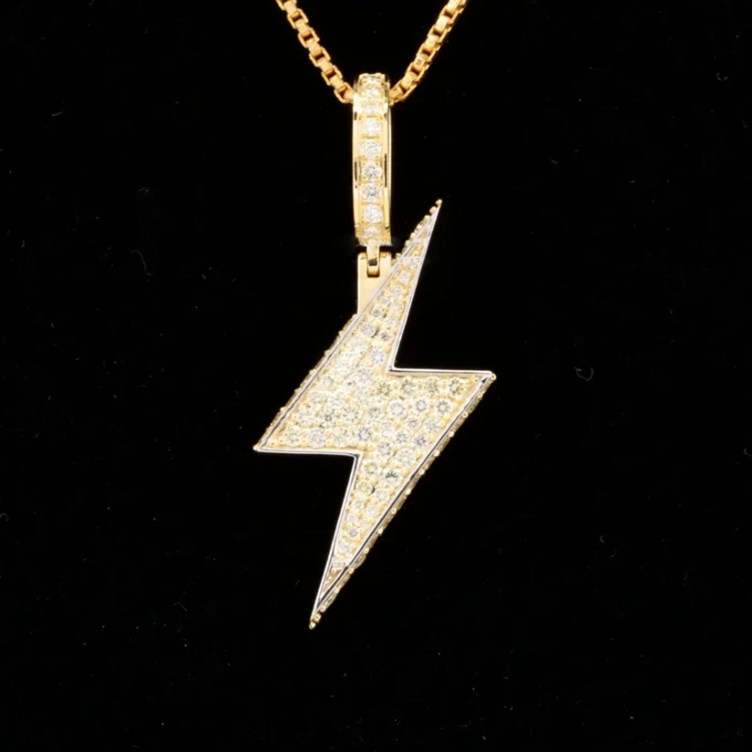 Gold iced out lightning bolt pendant necklace with diamond pave.