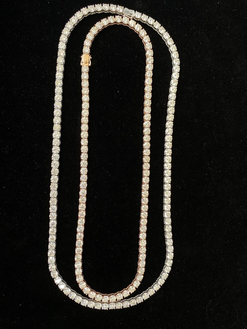 Front up of a round-cut stone tennis chain in rose gold plated setting against a black background