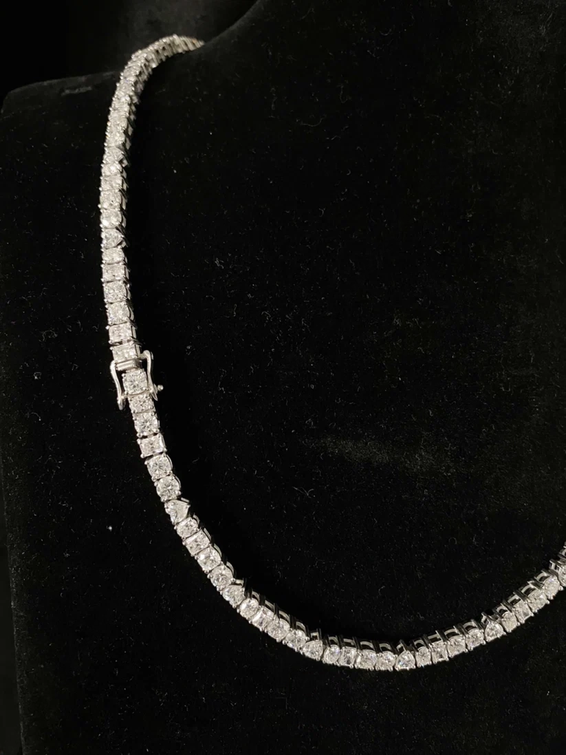 Close-up of a sparkling round-cut diamond tennis chain necklace with a secure clasp