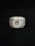 A silver diamond ring with a large round-cut center stone and channel-set side diamonds