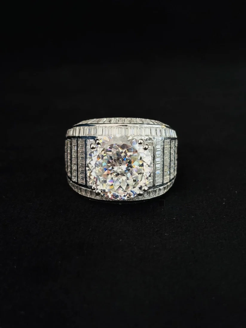 A silver diamond ring with a large round-cut center stone and channel-set side diamonds