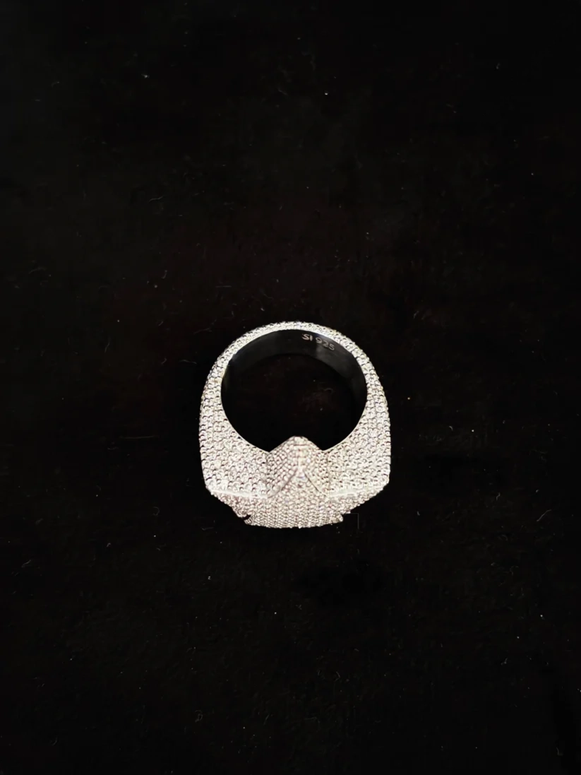 A silver ring with a heavily textured, pave-set stone surface, photographed from directly above