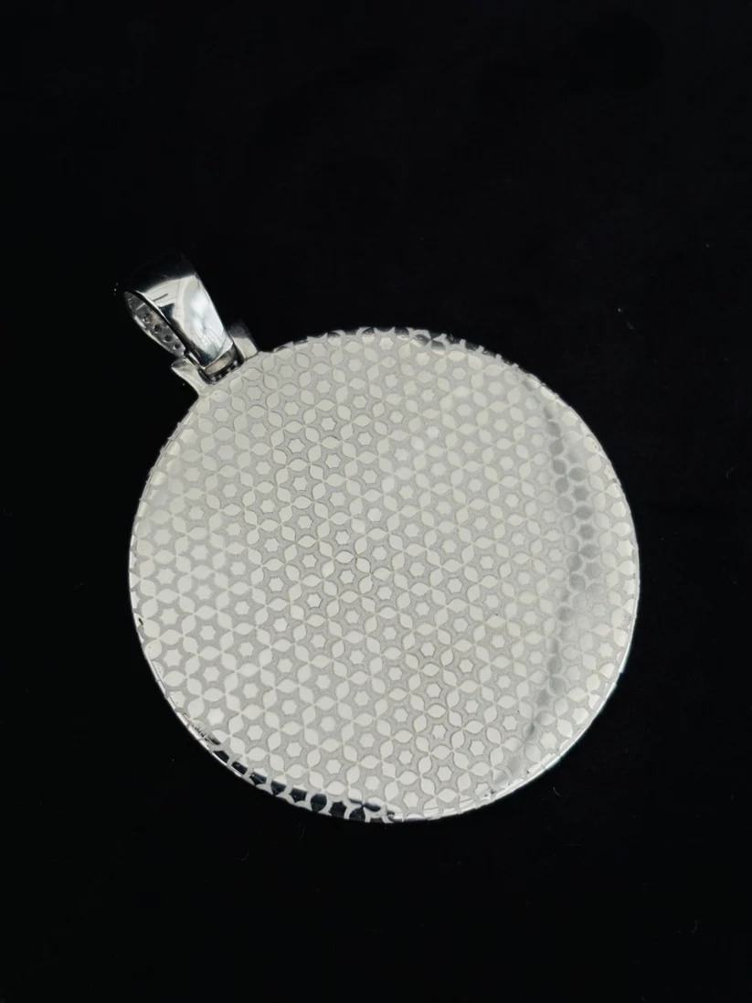 Round paved silver pendant with honeycomb textured surface and polished bail against a black background