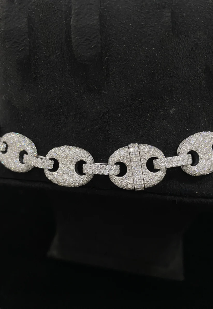 Close-up of a luxury sterling silver Gucci puffed anchor link chain bracelet paved with diamonds