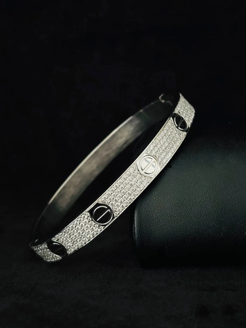 Cartier Love bracelet paved with diamonds in silver on dark background