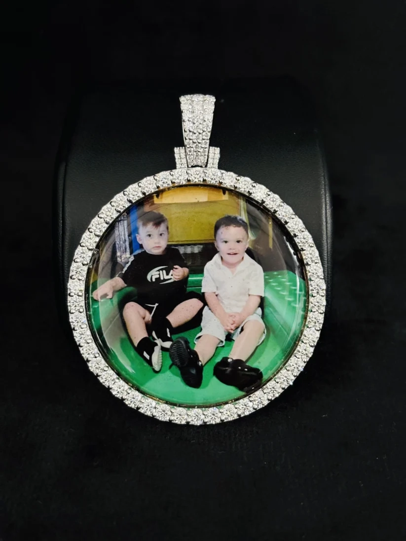 front view Custom round photo memory pendant with iced-out diamond border featuring a picture of two toddlers.
