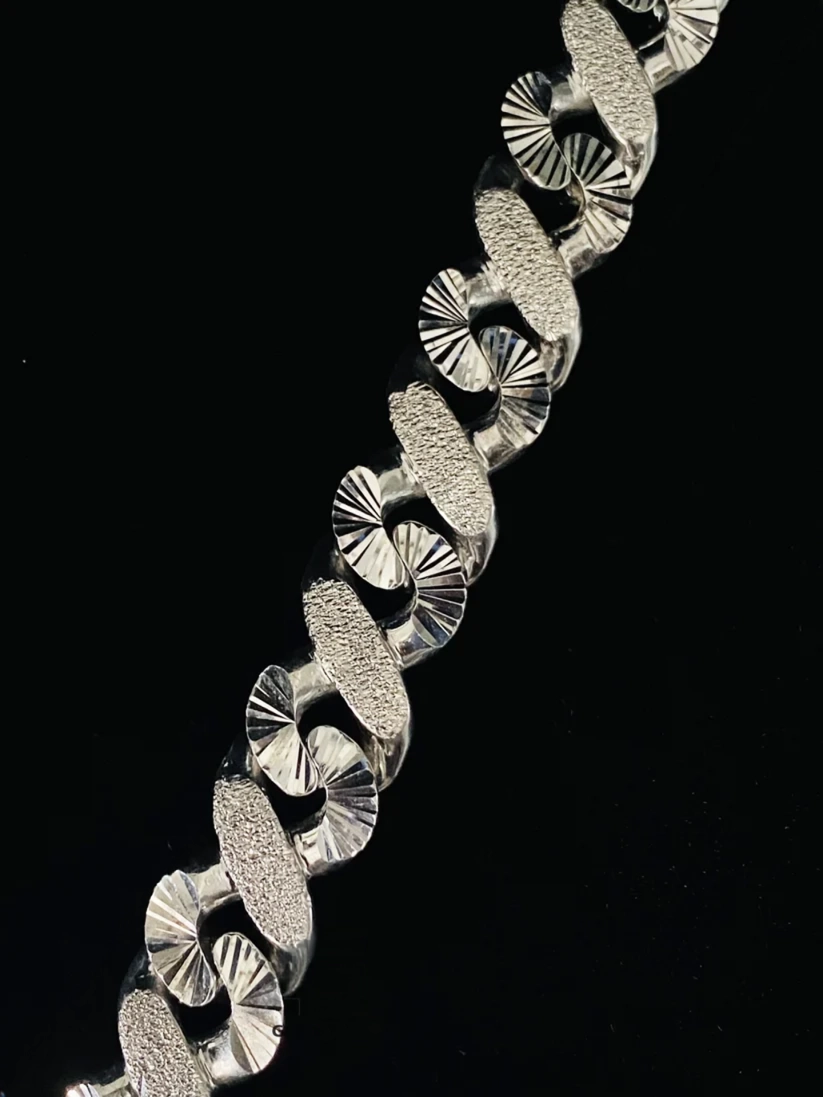 Silver Cuban link chain with diamond-cut and textured design